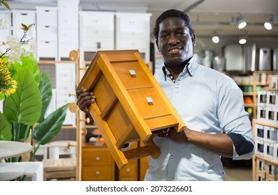 Portrait Of Man Choosing Dressing Table In Furniture Store