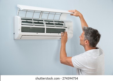 Portrait Of A Man Cleaning Air Conditioning System