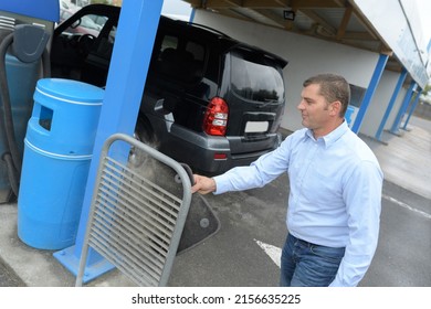 Portrait Of Man Cleaning Car Mat