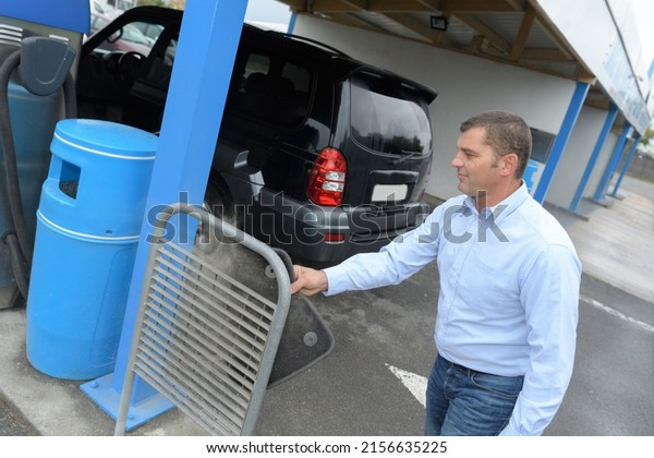 portrait of man cleaning car\
mat