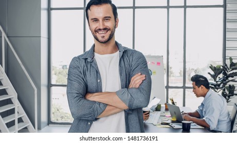 Portrait Of Man Creative Director Cross Arm Smile And Looking At Camera In Modern Office