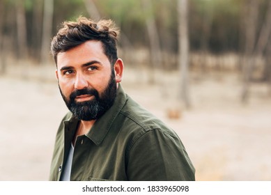 Portrait Of A Man With Dark Hair And Beard And A Green Shirt. Man Of 40-45 Years Old With A Captivating Look. Horizontal Photograph With Space For Copy