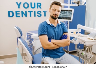 Retrato de un hombre dentista sentado junto a su equipo dental cubierto