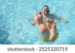 Portrait of man diving into water in swimming pool with feet up. Laughing cheerful middle aged male enjoy summer hot water. Summertime, fun, chill concept