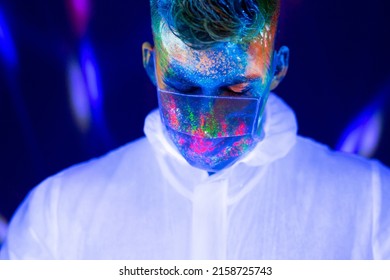 Portrait Of Man Doctor In Protective Clothes In Ultraviolet Neon Light During Coronavirus Pandemic. Epidemic, Pandemic Of Coronavirus Covid-19