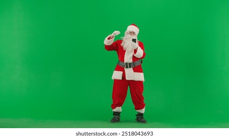 Portrait of man dressed as Santa on chroma key green screen background. Santa Claus watching sport game on smartphone, sad failed expression. - Powered by Shutterstock