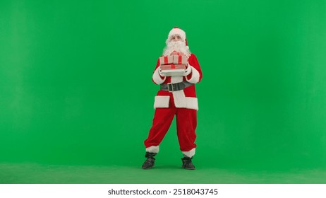 Portrait of man dressed as Santa on chroma key green screen background. Santa Claus in red outfit holding stack of gift boxes - Powered by Shutterstock