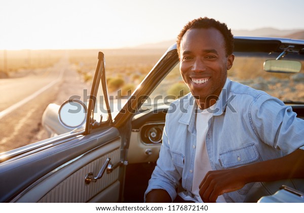 Portrait Of Man Enjoying Road Trip In Open Top\
Classic Car