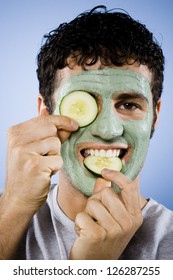 Portrait of man with facial mask and cucumber slices
