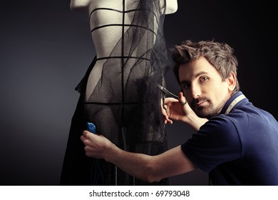 Portrait Of A Man Fashion Designer Working With Dummy At Studio.