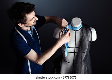 Portrait Of A Man Fashion Designer Working With Dummy At Studio.