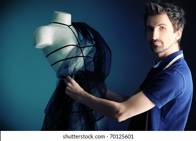 Portrait Of A Man Fashion Designer Working With Dummy At Studio.