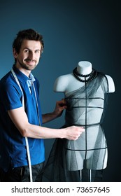 Portrait Of A Man Fashion Designer Working With Dummy At Studio.