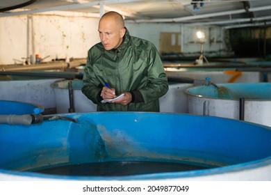 Portrait Of Man Fish Farm Worker At Trout Breeding Incubator