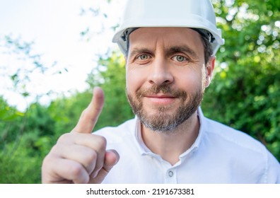 Portrait Of Man Foreman In Hardhat Pointing Finger Outdoors