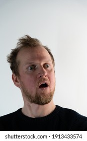 Portrait Of A Man With Frizzy Hair Looking Straight And Smiling Crazy When He Looks Like He Screaming