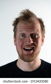 Portrait Of A Man With Frizzy Hair Looking Straight And Smiling Crazy When He Looks Like He Screaming