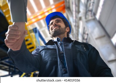 Portrait of a man giving an handshake in an industrial facility