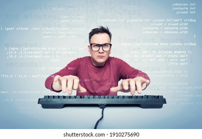 Portrait of a man in glasses and a red T-shirt who types on the keyboard and looks at the monitor with computer code. Front view.