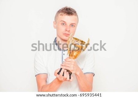 portrait of man handing gold cup up, isolated on white. Concept of leadership and success