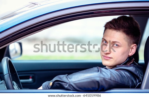 Portrait of a man in his car. Taxi driver\
concept. Happy automobile buyer. Test\
drive.