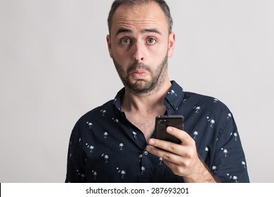 Portrait Of Man Holding A Phone With Suprise Expression.