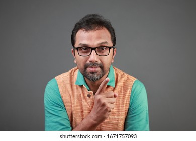 Portrait of a man of Indian ethnicity pointing his index finger