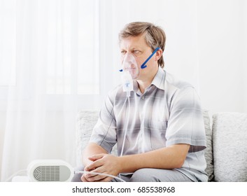 Portrait Of Man Inhaling Through Inhaler Mask