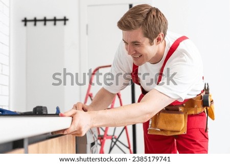 portrait of man installing kitchen hob