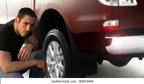 Portrait Of A Man Kneeling Down By Large Pickup Truck