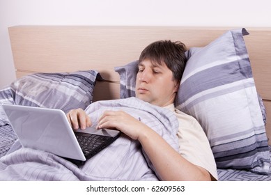 Portrait Of The Man With Laptop In Bed