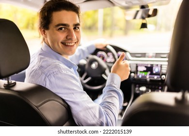 Portrait Of A Man Looking Back Sitting On The Front Seat Of The Car