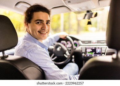 Portrait Of A Man Looking Back Sitting On The Front Seat Of The Car