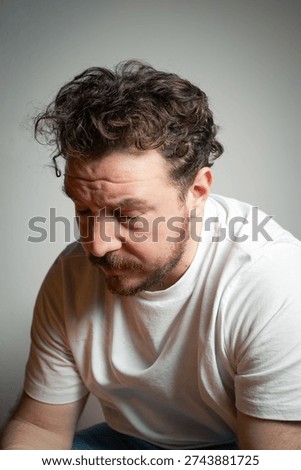 Portrait of a Man Looking Down with an Expression of Guilt and Regret