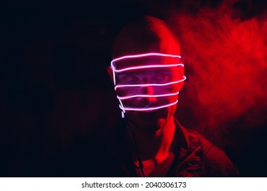 Portrait Of Man With Neon Glow Tube Lines On His Face In Dark. Concept Cyberpunk And Virtual Reality