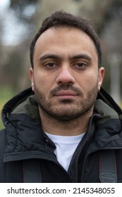 Portrait Of Man. No Expression On His Face. Outdoor Background. Close Up Photo.