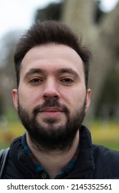 Portrait Of Man. No Expression On His Face. Outdoor Background. Close Up Photo.