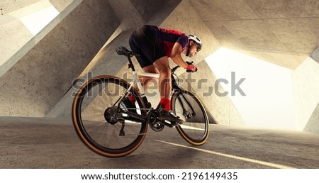 Portrait of man, professional cyclist training, riding on professional sport bike around city on a daytime. Concept of sport, lifestyle, health, outdoor training. Developing speed and endurance.