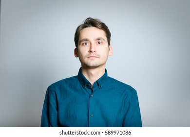 Portrait Of Man With A Serious Face, Isolated On A Gray Background