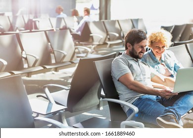 Portrait of man showing funny picture with his wife while waiting in airport - Shutterstock ID 1661889460