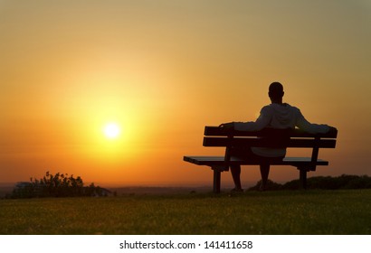 Portrait of a man sitting on a bench enjoying the Sunset - Powered by Shutterstock