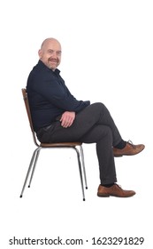 Portrait Of A Man Sitting On A Chair In White Background, Looking At Camera