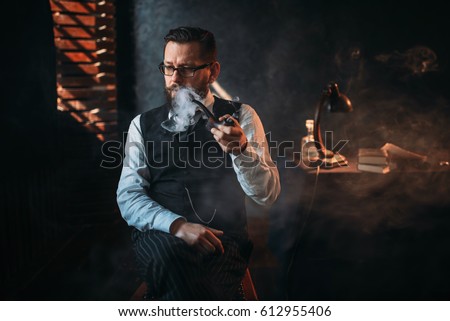 Portrait of man sitting on chair and smoking pipe