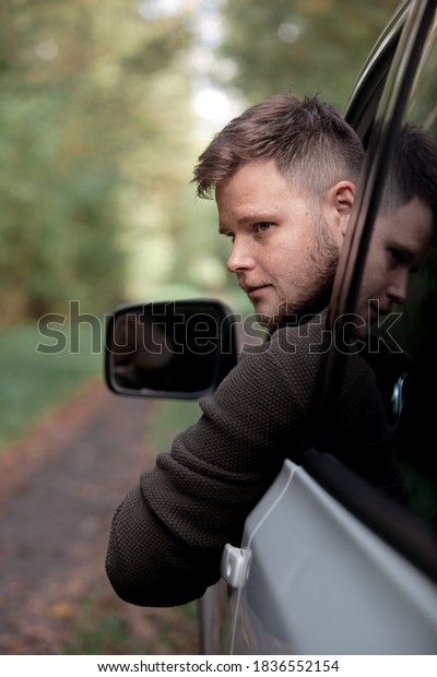 portrait of a man stick\
out of car window