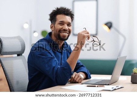 Portrait of man at table in office