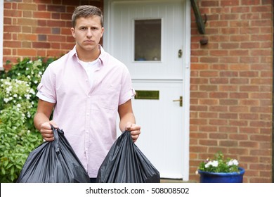 Portrait Of Man Taking Out Garbage In Bags