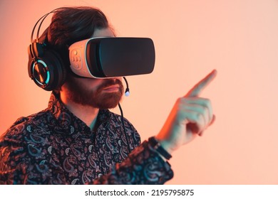 Portrait Of A Man With A Vr Headset And Headphones Touching The Invisible Touchscreen Panel - Virtual Reality Experience. High Quality Photo