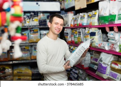 Portrait Of Man Watching Diet Products And Smiling In Pet Store