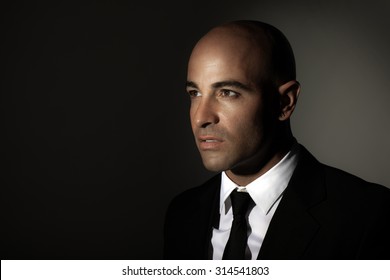 Portrait Of A Man Wearing Black Suit, White Shirt And Stylish Tie, Standing Over Dark Background With Copy Space, Expensive Outfit, Fashion And Business Lifestyle