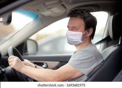 Portrait Of Man Wearing Disposable Medical Facemask In A Car During Coronavirus Outbreak. Safety In The City.